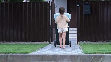 little girl pushing a garbage container, trash can. Garbage collection video