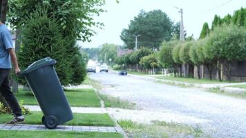 a man rolls a garbage container, a trash can video