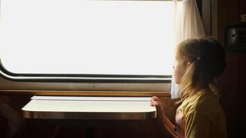little girl riding in train compartment car and looking out window video