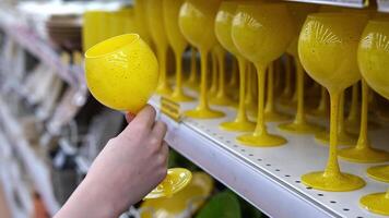 Young woman chooses glasses for wine close-up. Buying tableware video
