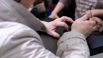 Faceless Elderly woman pays for a purchase with a bank card through a payment terminal and enters a pin code video