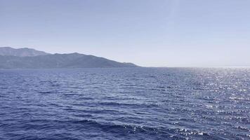 Seagull flying over serene ocean with mountains in the background video