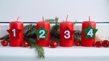 Traditional four advent weeks before Christmas holidays. Red candles with numbers and plastic free decoration. Copy space greeting card mock up template. Winter cozy home time photo