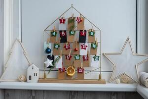 Number on craft paper notes with tasks before Christmas holidays. Female making kraft paper for handmade advent calendar Made with your own hands step by step DIY crafts do it yourself photo
