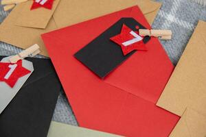 Number on craft envelopes notes with tasks before Christmas holidays. Female making kraft paper for handmade advent calendar Made with your own hands step by step DIY crafts do it yourself photo