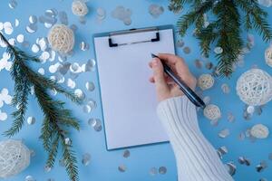 Woman writing letter to SANTA or promises and aims. Empty notebook Preparation for new year. Visualizing wish list for 2025. Dreams plan action resolutions for coming year. Inspirational self improvement concept photo