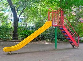 Yellow joyful slide for child and kids in Japanese residential playground photo