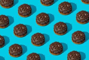 Creative trendy pattern made of sweet cookies on bright blue background. Minimal tasty biscuits concept. Yummy sweet food pattern background idea. Cookies aesthetic. photo