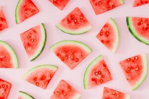 Trendy summer fruit pattern made with watermelon slices on light pastel pink background. Minimal summer concept. Creative food backdrop idea. Watermelon aesthetic. photo