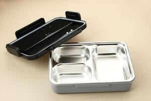 Empty Stainless Lunch box with compartments on wooden background photo