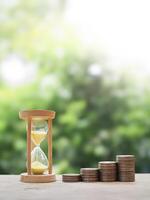 Hourglass and stack of coins. The concept of saving money for manage time to success business photo