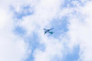 Looking up at an aeroplane in the middle of clouds from bottom photo