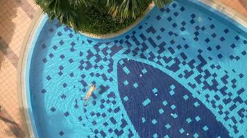 Aerial view of caucasian woman swimming on the back in the pool on vacation video
