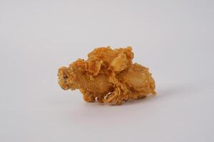 Golden brown fried chicken on white background. Fried chicken isolated over white. Fried chicken isolated on white background. Crispy fried chicken pieces in mid-air with crumbs scattering isolated photo