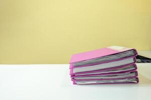 Stack of account file documents on white desk photo