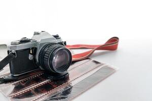 Retro camera with red strap on film negative roll photo