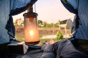 View from inside of tent with relaxing and campfire near swamp in evening photo
