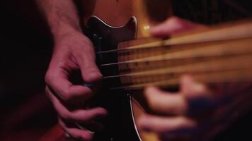 Guitar player close up playing on an electric guitar in low light during the performance in the studio. Guitarist delicately performing a song video