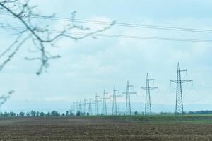 High voltage towers with sky background. Power line support with wires for electricity transmission. High voltage grid tower with wire cable at distribution station. Energy industry, energy saving photo