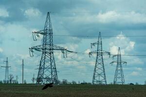 High voltage towers with sky background. Power line support with wires for electricity transmission. High voltage grid tower with wire cable at distribution station. Energy industry, energy saving photo