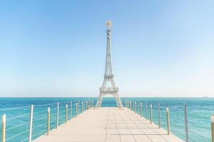 Large model of the Eiffel Tower on the beach. photo