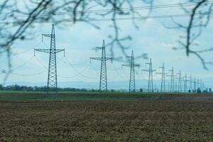 High voltage towers with sky background. Power line support with wires for electricity transmission. High voltage grid tower with wire cable at distribution station. Energy industry, energy saving photo