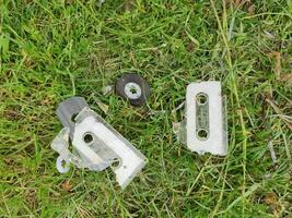 broken tape cassette in the grass flat view photo