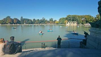 Madrid, España 10.08.2024 paseo en barco en un sereno lago en Madrid parque, un tranquilo escena de un lago en un Madrid parque, dónde varios pequeño barcos son suavemente flotante en el agua video