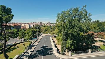 ver de un la carretera devanado mediante un parque en Madrid, un elevado ver de un la carretera devanado mediante un lozano parque en Madrid, con el de la ciudad horizonte visible en el antecedentes video