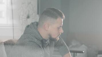 Man deep in thought with soft lighting in a modern room, A man is captured deep in thought, with a soft, diffused light filling the modern room. video