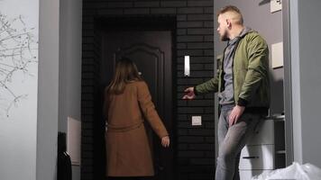 Couple holding hands in a hallway, one about to leave, The moment captures a tender and emotional connection, with the person in the coat standing near the door, video