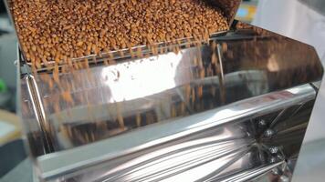 Grain being poured and filtered through a machine, A close-up view of grains being poured and filtered through a commercial machine. video