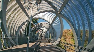 Madrid, Spain 10.08.2024 Futuristic pedestrian bridge in a Madrid park, A modern pedestrian bridge with an intricate metallic structure in a park in Madrid. video
