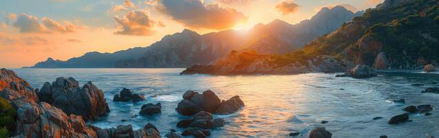 Sunset over rocky coastline with mountains in the background photo