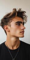 Young man with stylish haircut posing against a simple background photo
