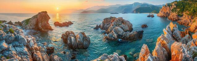 Sunset over rocky coastline with mountains in the background photo