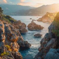 Rocky coastline with mountains at sunset near the ocean photo