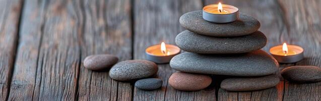 Zen candle arrangement with stacked stones on a wooden surface photo