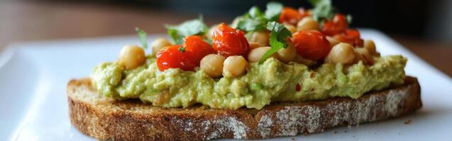Fresh avocado hummus toast topped with cherry tomatoes and herbs photo