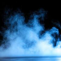 Gentle blue mist rises slowly over a calm surface in dim light photo