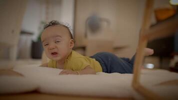 A cute baby is exploring and enjoying playtime on a soft mat in a warm and cozy home environment video