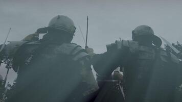 Armored soldiers, preparing for battle, stood in a field enveloped in mist, ready for combat video
