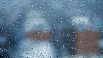 A rainy view through a window, blurred background with water droplets, creating calm atmosphere video