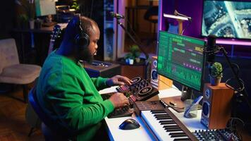 Skilled music producer composing new soundtracks on console and daw software, working with stereo gear in home studio. Young artist engineer uses pre amp knobs, signal processing. Camera B. video