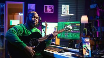 Talented performer teaching how to play acoustic guitar online for a tutorial, hosting internet master class to provide advice for beginners. Artist composer explaining accords on strings. Camera B. video
