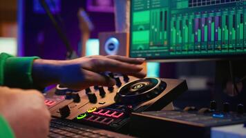 Audio engineer producing new music on mixing console in home studio, working with sound effects and pre amp knobs. Skilled producer creating songs and adjusting volume levels. Close up. Camera B. video