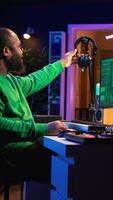 Vertical Sound producer working with console and electronic keyboard to create perfect tracks for his songs, recording and editing audio. Music composer adjusts volume levels on pre amp knobs. Camera B. video