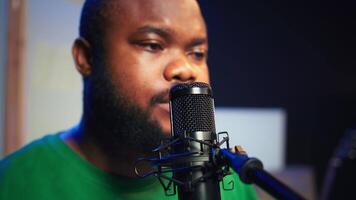 Skilled composer producing a new melody with lyrics and piano keys, recording audio files to edit them with mixing console. Young talented artist producer creating soundtracks. Camera B. video