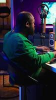 Vertical Artist playing electronic piano keyboard notes and recording audio files to use mix and master techniques, editing recordings to edit sound effects. Musician operating on synthesizer gear. Camera B. video
