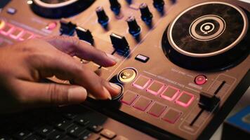 Audio engineer with headset mixing and mastering his recorded files, operating on a professional soundboard in home studio. Artist producer composing new tracks with sound effects. Camera A. video
